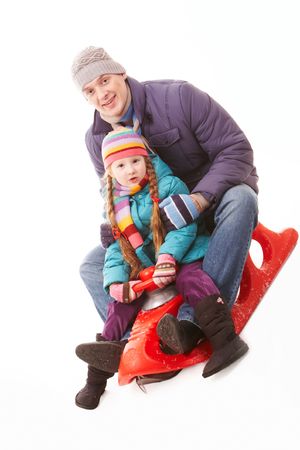 Happy girl and her father sitting on sledge and having funの写真素材