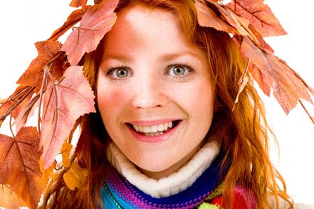 Portrait of smiling young woman wearing wreath of maple leaves  の写真素材