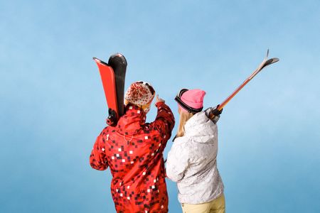 Back view of sporty couple pointing at something over blue backgroundの写真素材