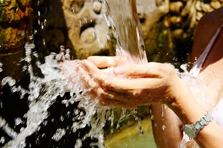 Image of human hands catching water splashes