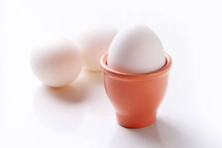 Image of fresh egg in clay form against white backgroundの写真素材