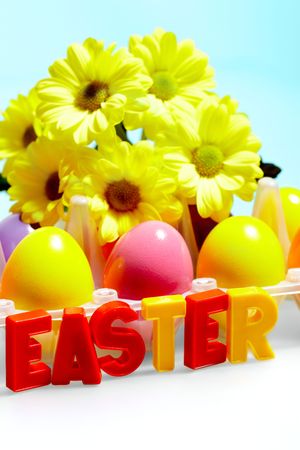 Image of colored letters with painted Easter eggs and flowers near by