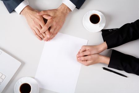 Above view of business people hands on workplace with blank paper near by Above view of business people hands on workplace with blank paper near by