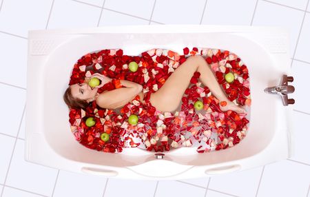 Portrait of attractive woman lying in the bathtub and eating apple  の写真素材