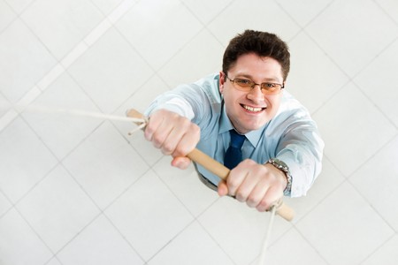 Image of happy businessman holding on the ladder and looking at cameraの写真素材
