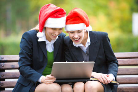 Image of two businesswomen with red hats in the park 
