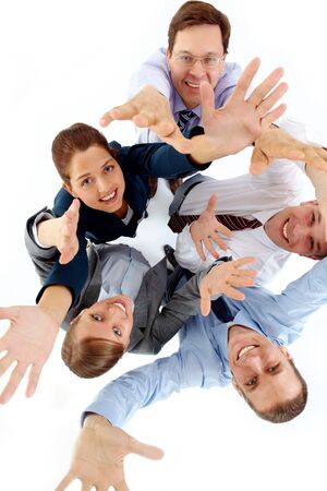 Above view of several successful partners raising arms and looking at camera 