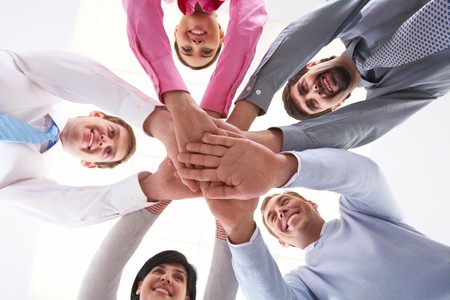 Below shot of smiling co-workers making pile of handsの写真素材