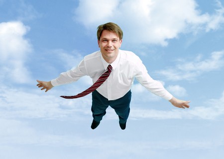 Conceptual image of happy businessman flying in the cloudsの写真素材