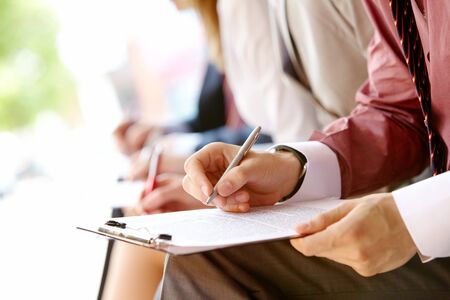 Human hand over paper making notes in working environment  の写真素材