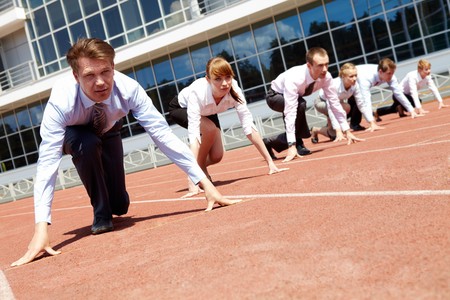 Confident business people lined up getting ready for race