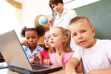 serious classmates and teacher looking at the laptopの写真素材