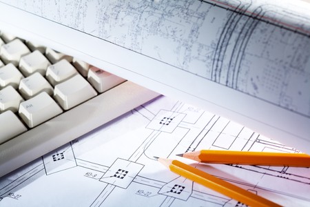 Close-up of blueprints with sketches of projects, pencils and computer keypadの写真素材