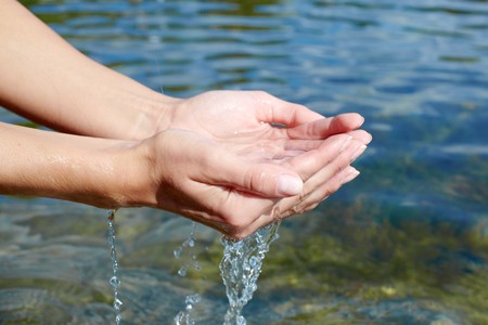 Human hands splashing pure water from riverの写真素材
