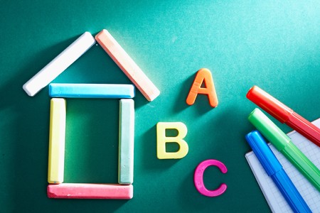 Close-up of chalk house, letters and highlighters on blackboardの写真素材