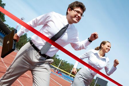 Photo of successful businessman crossing finish line during race の写真素材