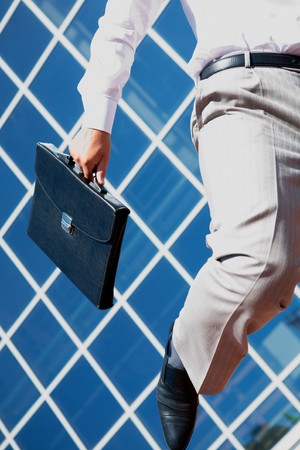 Close-up of businessman with briefcase runningの写真素材