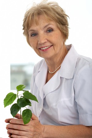 Portrait of kind and friendly woman with green plantの写真素材