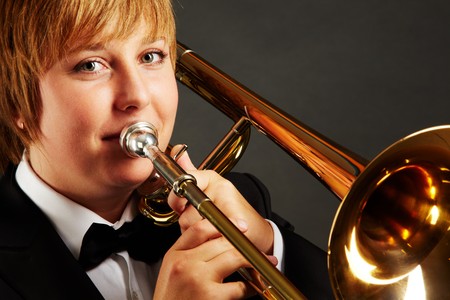 Portrait of young female playing the trombone and looking at camera