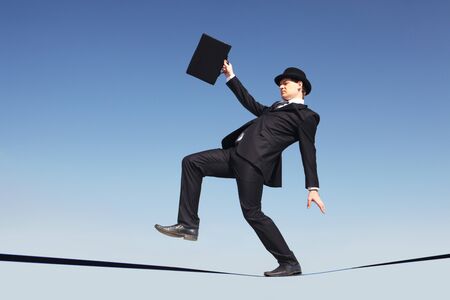 Photo of careful businessman standing on ribbon or rope running risk of falling down