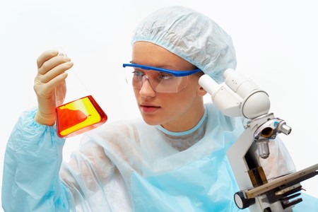 Portrait of medical student looking at flask with microscope near by in laboratoryの写真素材