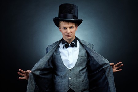 Image of male magician in hat and tail-coat looking at cameraの写真素材