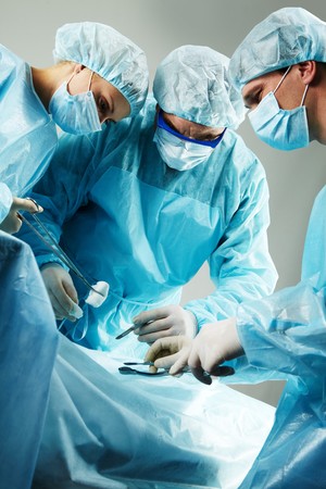 Three surgeons busy with a patient の写真素材