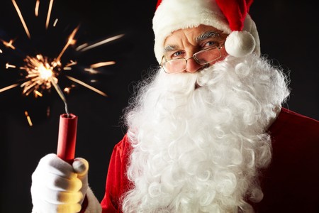 Portrait of Santa with a burning stick of dynamite isolated on blackの写真素材