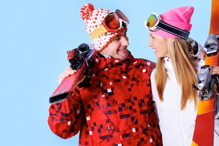 Portrait of happy couple with skis in hands looking at each other and smilingの写真素材