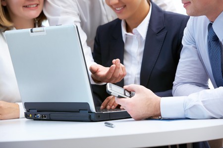 Close-up of business people aroung laptop working in groupの写真素材