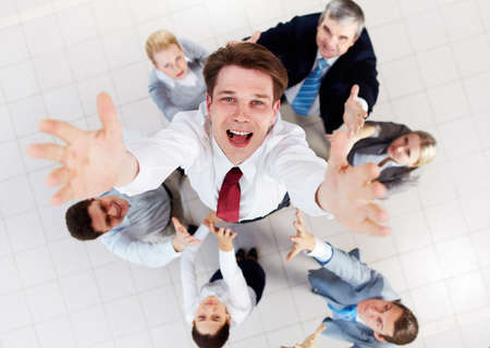 Above view of happy employer looking at camera while being thrown by several partnersの写真素材