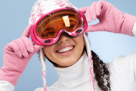 Happy woman in goggles and knitted winter capの写真素材