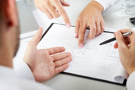 Close-up of team working with documents at business meetingの写真素材