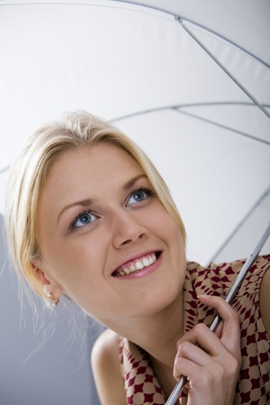 Lovely girl under umbrella smilingの写真素材