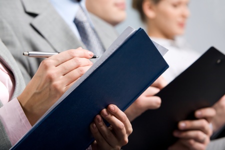 Business education: people making notes at conferenceの写真素材