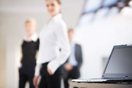 Photo of black laptop on the background of business peopleの写真素材