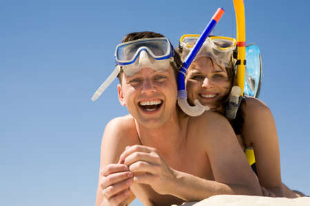 Portrait of cheerful divers lying on sand and enjoying themselvesの写真素材