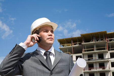 Portrait of confident foreman calling by the phone and holding document の写真素材