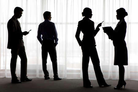 Four outlines of business partners interacting and doing their workの写真素材