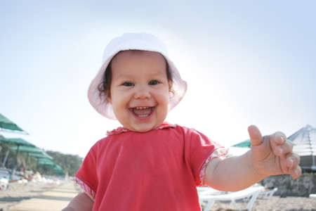 Portrait of happy baby stretching her arm to camera and smilingの写真素材