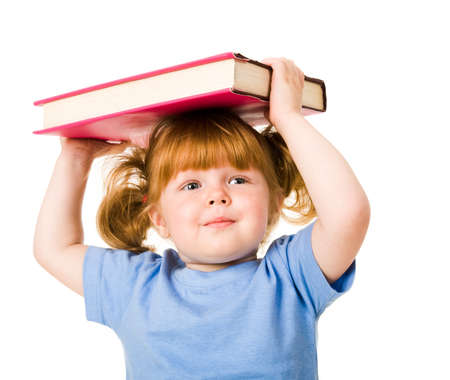 Portrait of young smiling child holding textbook over her head  の写真素材