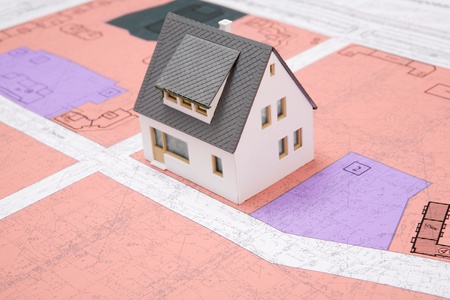 Close-up of toy house model on blueprints with its design の写真素材