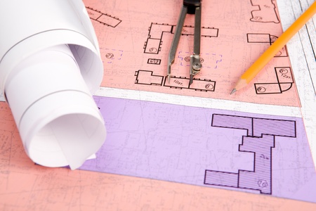 Close-up of blueprints with sketches of projects on workplace and some mechanical tools