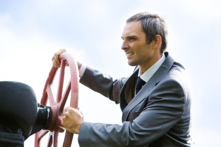 Portrait of confident captain holding rudder while steeringの写真素材