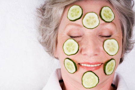 Face of mature woman with cucumber slices on itの写真素材