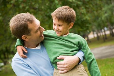 Image of happy man holding his son on hands outsideの写真素材