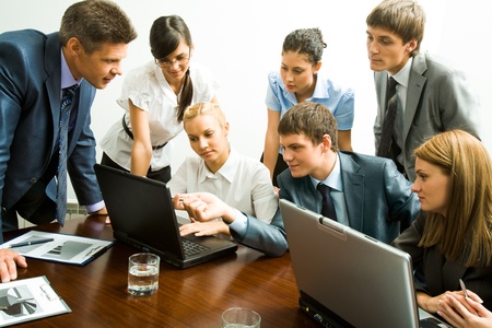 Image of company of successful partners looking at laptop monitorの写真素材