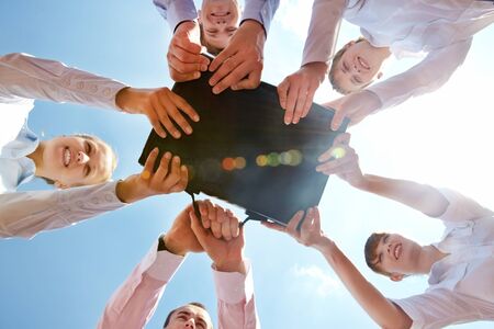 Below angle of businesspeople holding black leather briefcase simultaneouslyの写真素材
