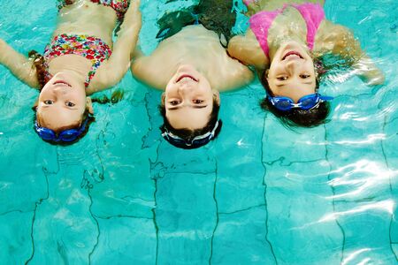 Photo of happy friends looking at camera in poolの写真素材