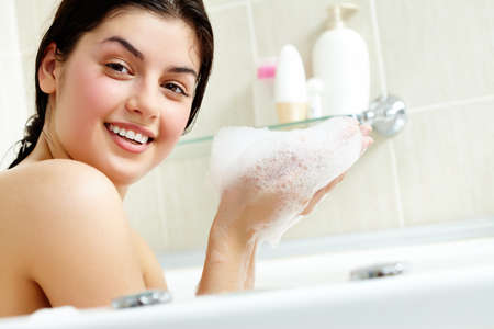 Pretty girl with foam in hands looking at camera